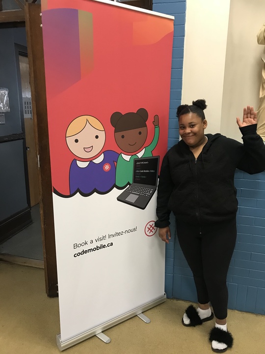 girl standing in front of Code Mobile banner