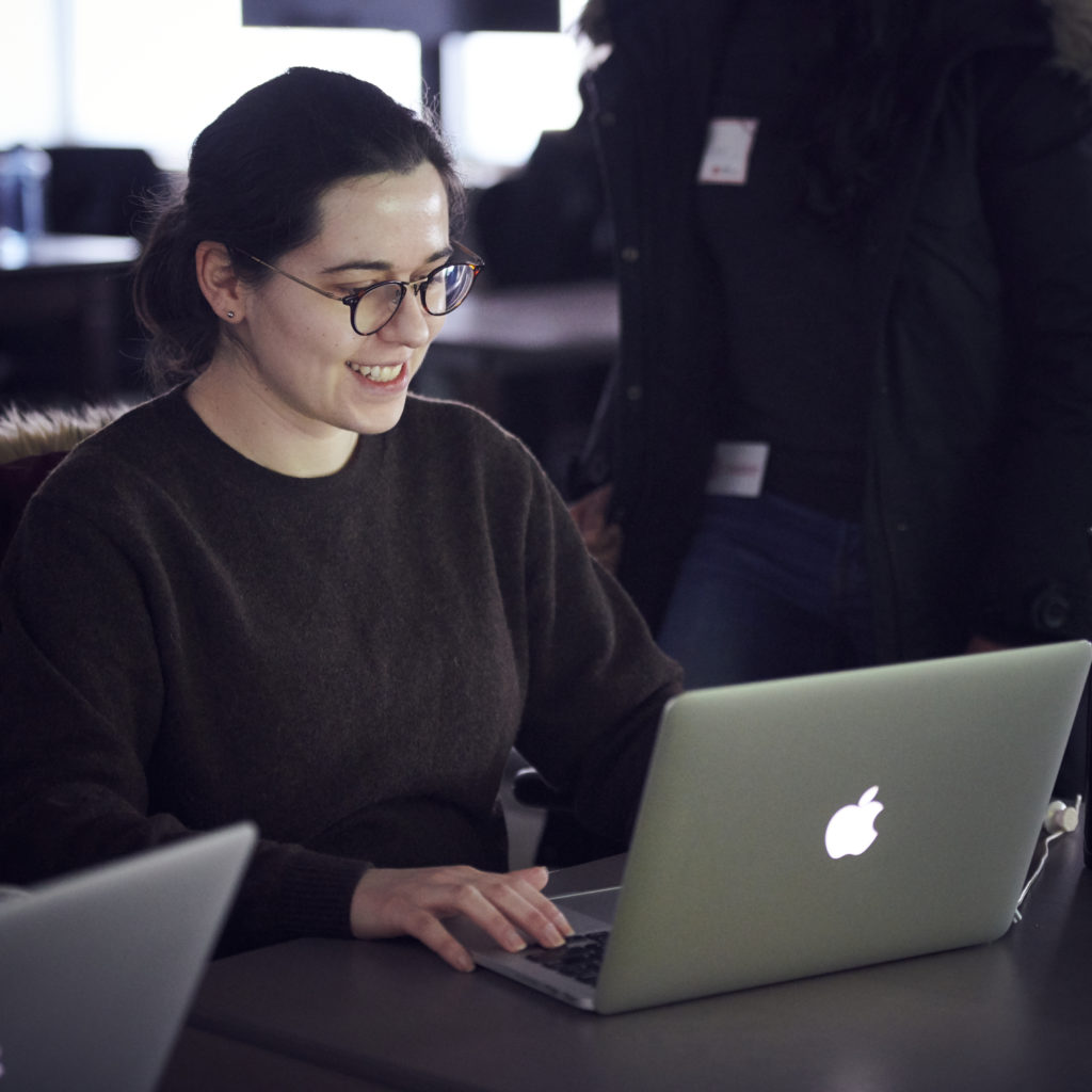 Female learner smiling while looking at her laptop