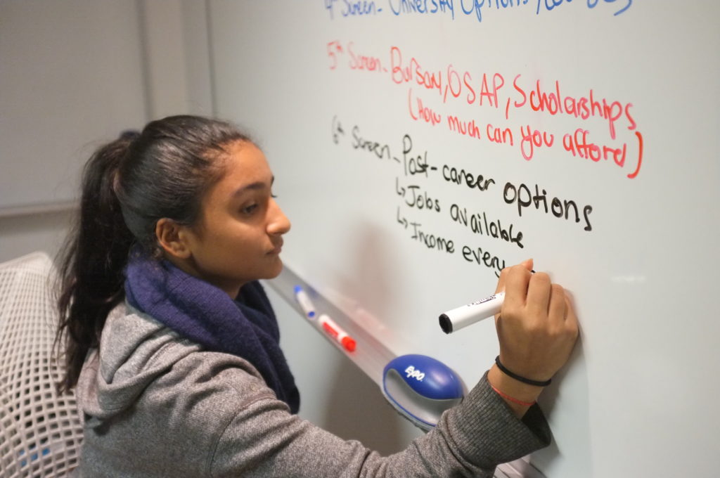 Ten girl is writing on a blackboard