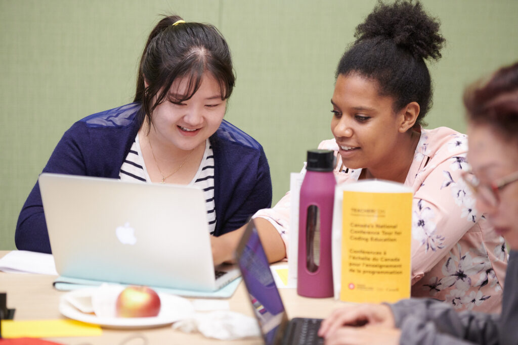 Two women looking at their laptop