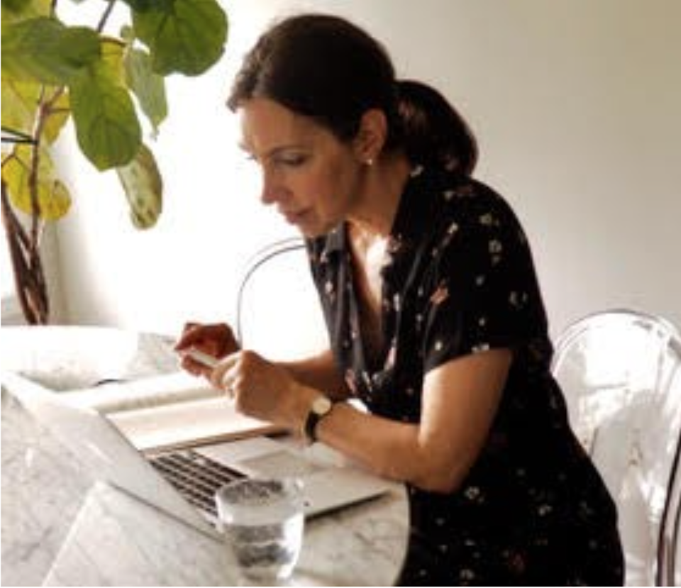 Woman sitting at desk in front of laptop