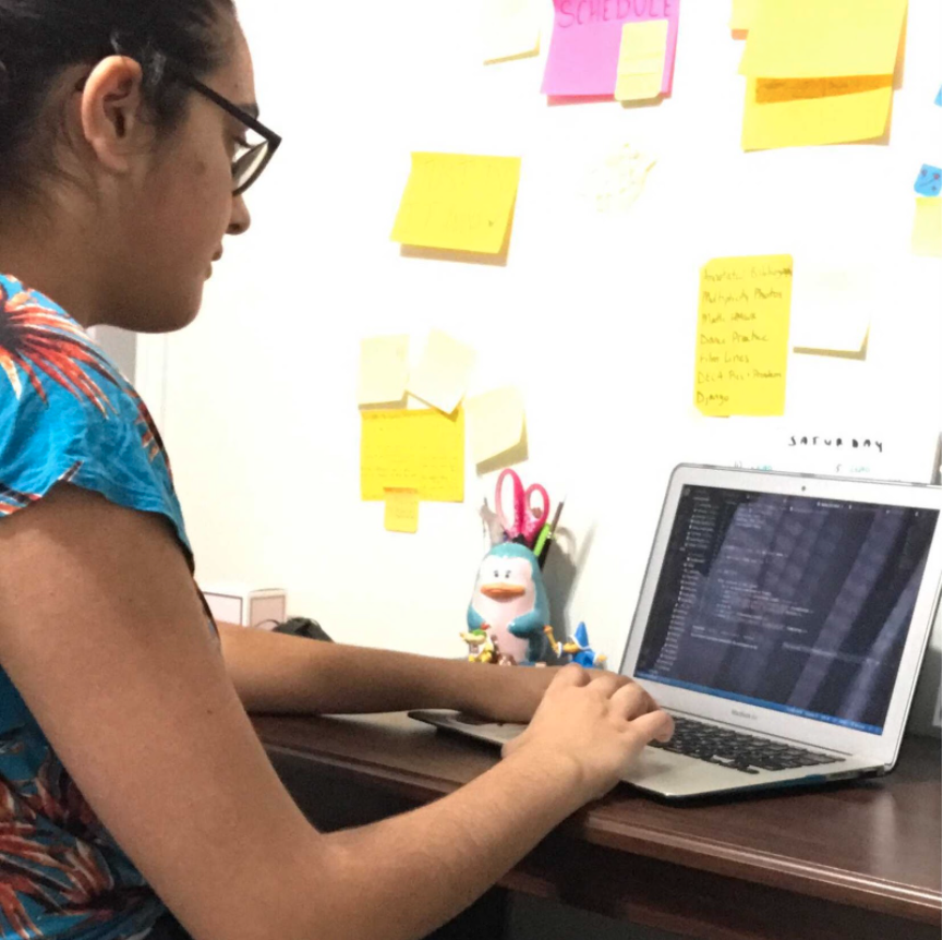 Teen girl coding on her laptop