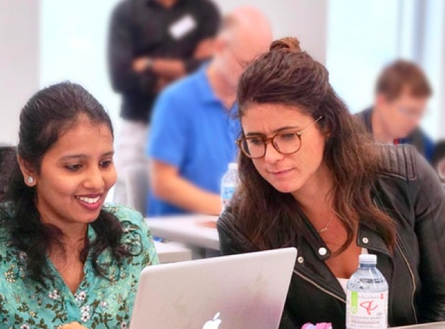 female mentor looking over to female learner's laptop