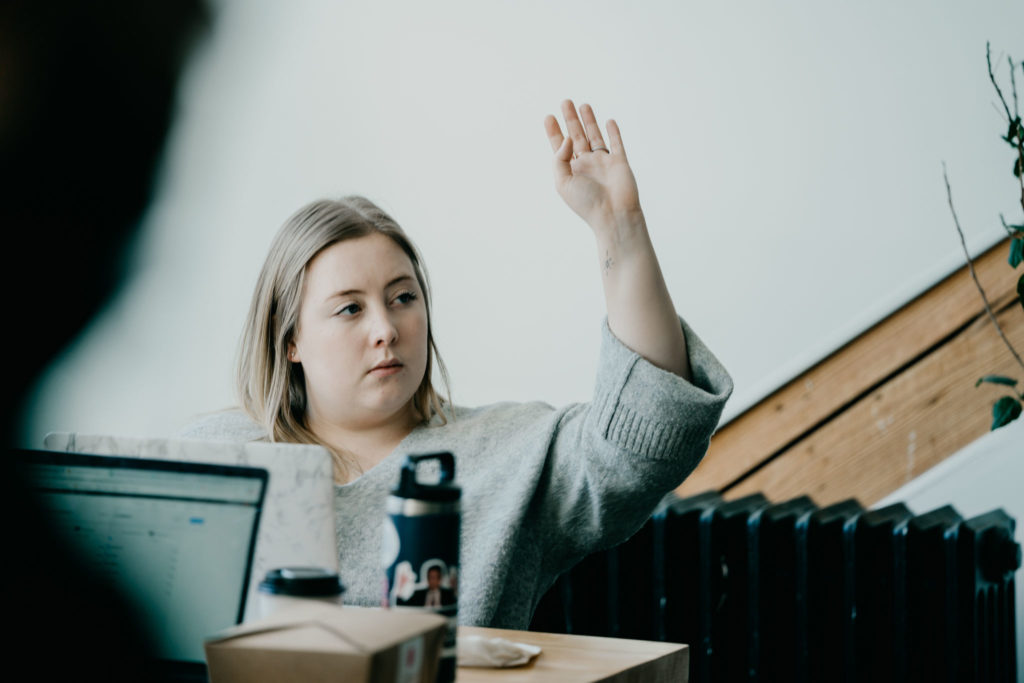 Female-identified participant raising their hand 