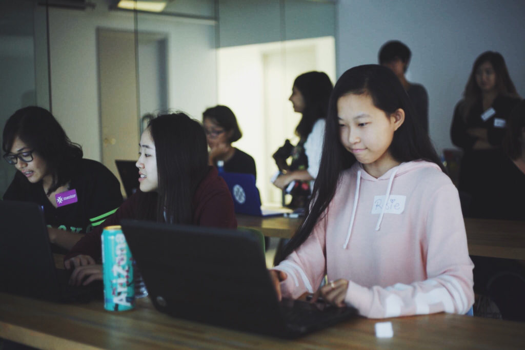 Teen girl is typing something on her laptop 