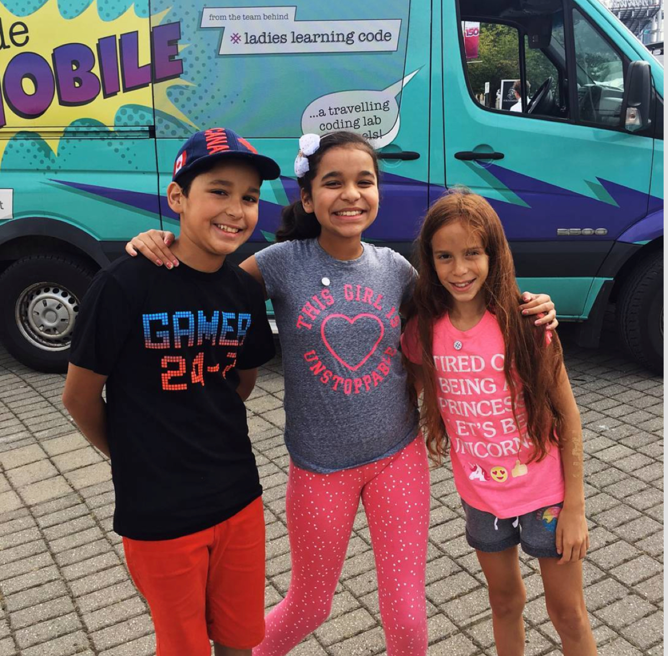 children posing in front of the code mobile